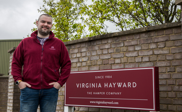 Employee stands next to Virginia Hayward Hamper company sign in Dorset.