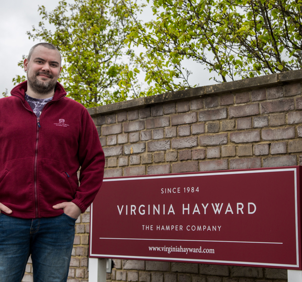 Employee stands next to Virginia Hayward Hamper company sign in Dorset.