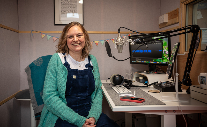 Natalie Cooper sat at desk with laptop and microphone