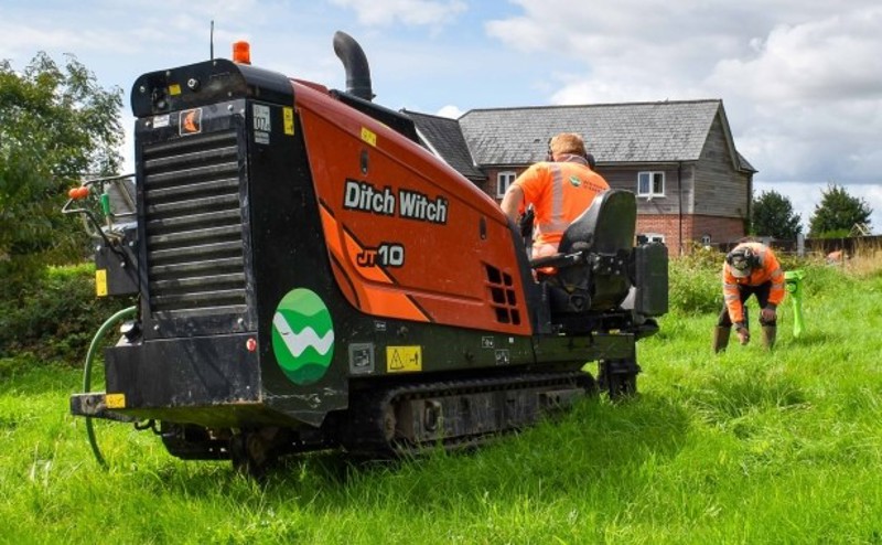 Two males operating a Ditch Witch.