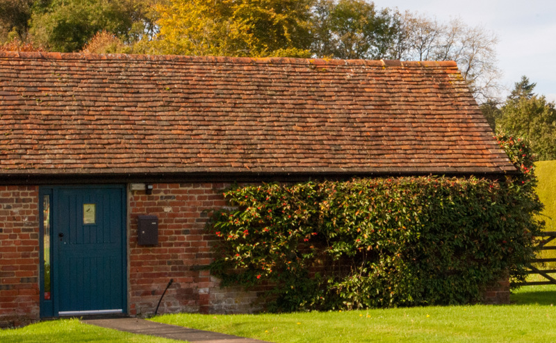 A farmhouse building with blue door that hosts Hotbox Studios in Hook, South West England. 