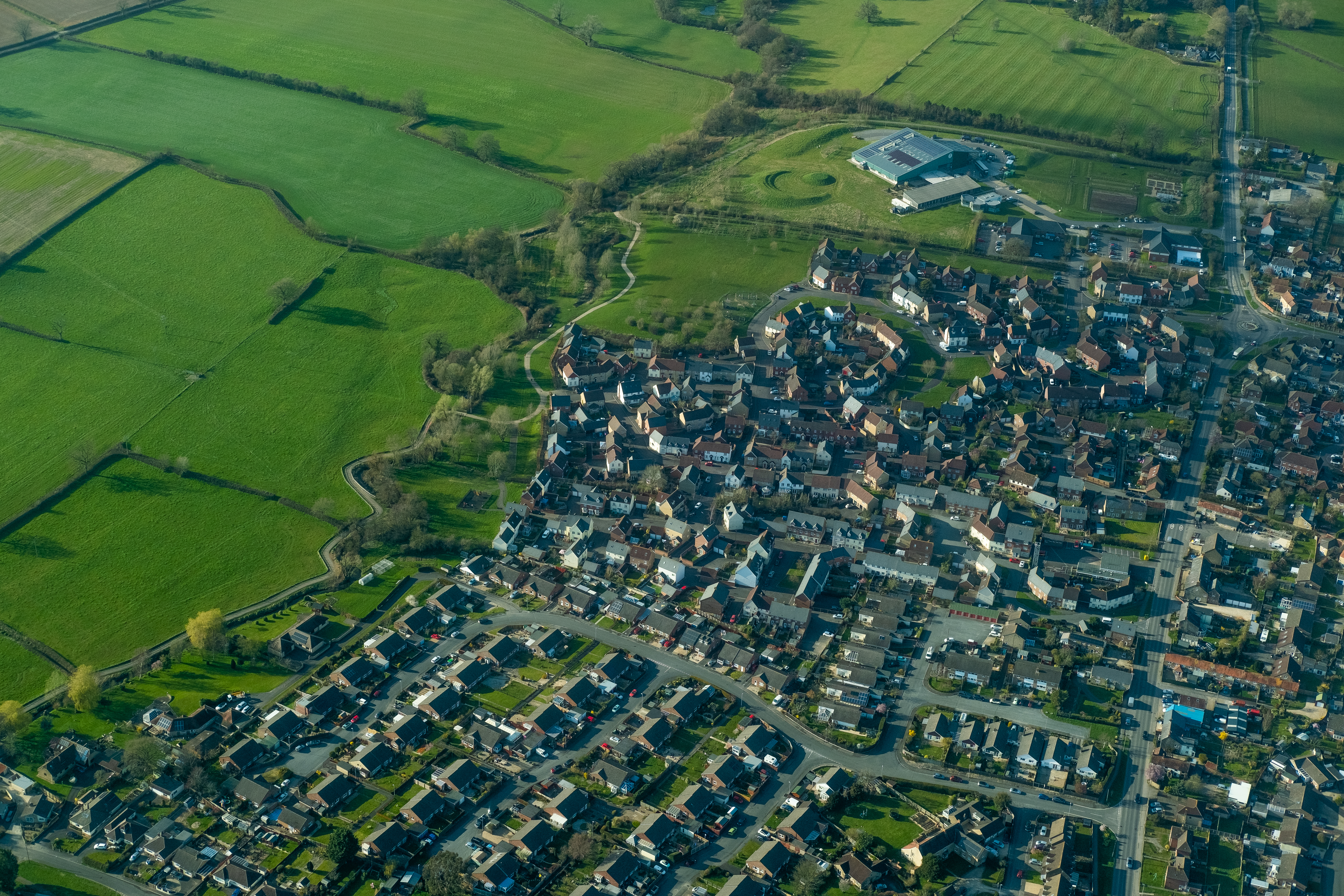 Aerial view of green fields and houses